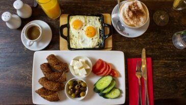 A plate of breakfast with toast, eggs, and vegetables served on a table.