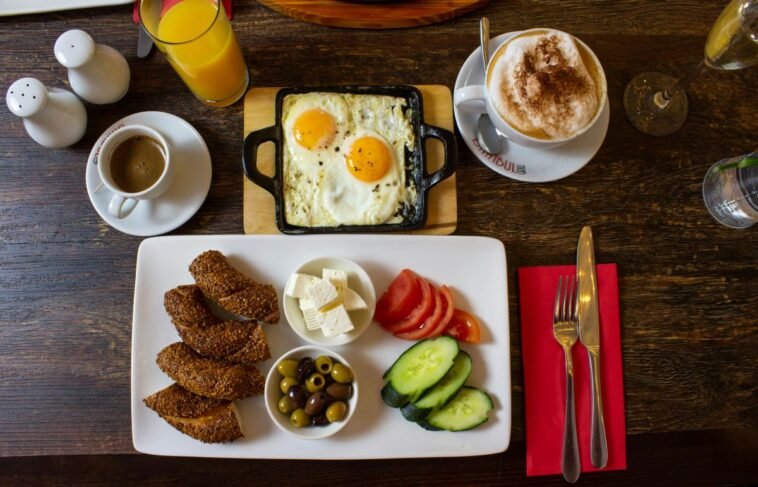 A plate of breakfast with toast, eggs, and vegetables served on a table.